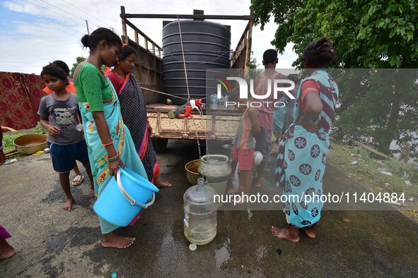 Flood-affected villagers are collecting drinking water from a relief camp conducted by the Public Health Centre (PHC) in Jakhalabandha, Naga...