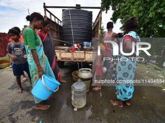 Flood-affected villagers are collecting drinking water from a relief camp conducted by the Public Health Centre (PHC) in Jakhalabandha, Naga...