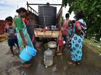 Flood-affected villagers are collecting drinking water from a relief camp conducted by the Public Health Centre (PHC) in Jakhalabandha, Naga...