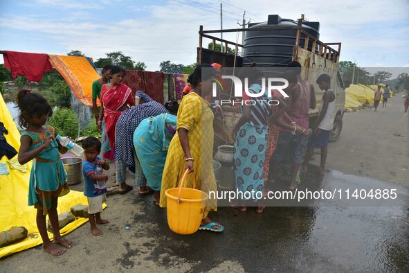 Flood-affected villagers are collecting drinking water from a relief camp conducted by the Public Health Centre (PHC) in Jakhalabandha, Naga...