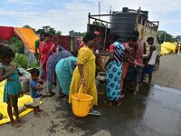 Flood-affected villagers are collecting drinking water from a relief camp conducted by the Public Health Centre (PHC) in Jakhalabandha, Naga...