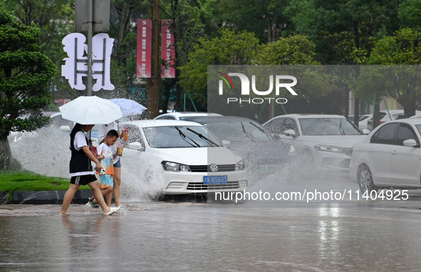 Citizens are traveling on a flooded road in Neijiang, Sichuan province, China, on July 13, 2024. 