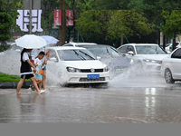 Citizens are traveling on a flooded road in Neijiang, Sichuan province, China, on July 13, 2024. (