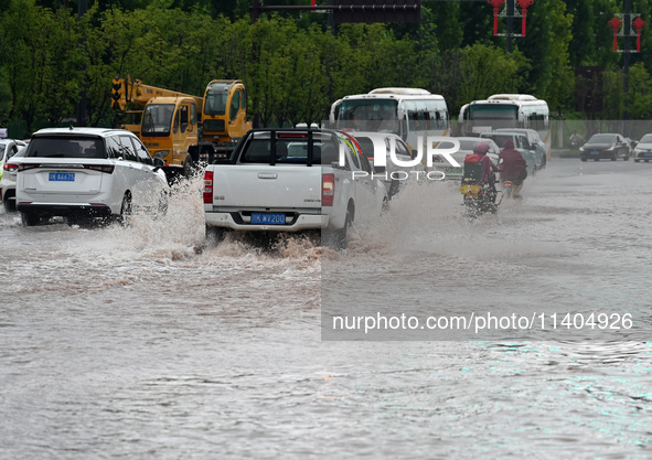 Citizens are traveling on a flooded road in Neijiang, Sichuan province, China, on July 13, 2024. 