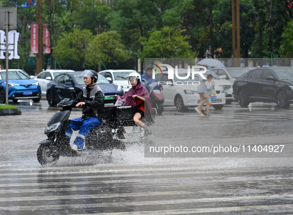 Citizens are traveling on a flooded road in Neijiang, Sichuan province, China, on July 13, 2024. 