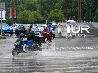 Citizens are traveling on a flooded road in Neijiang, Sichuan province, China, on July 13, 2024. (