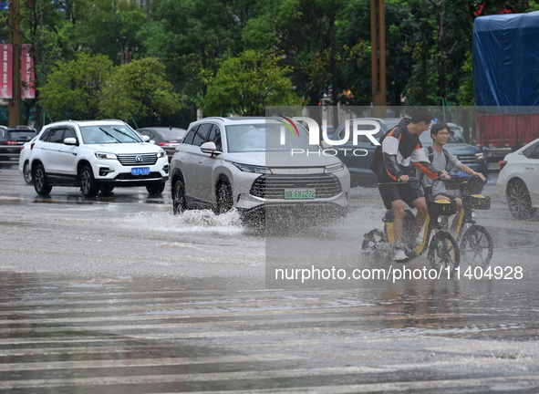 Citizens are traveling on a flooded road in Neijiang, Sichuan province, China, on July 13, 2024. 