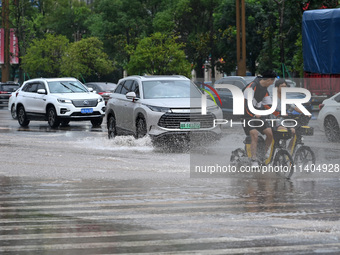 Citizens are traveling on a flooded road in Neijiang, Sichuan province, China, on July 13, 2024. (