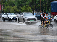 Citizens are traveling on a flooded road in Neijiang, Sichuan province, China, on July 13, 2024. (