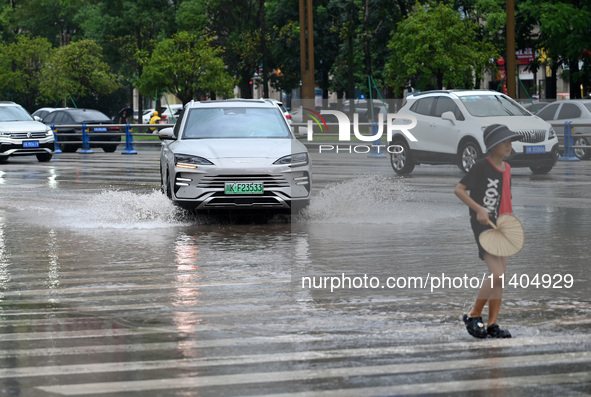 Citizens are traveling on a flooded road in Neijiang, Sichuan province, China, on July 13, 2024. 