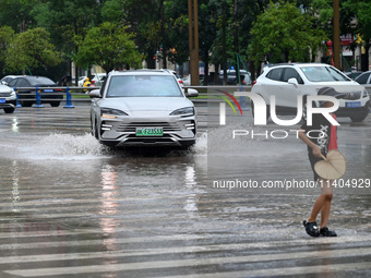 Citizens are traveling on a flooded road in Neijiang, Sichuan province, China, on July 13, 2024. (