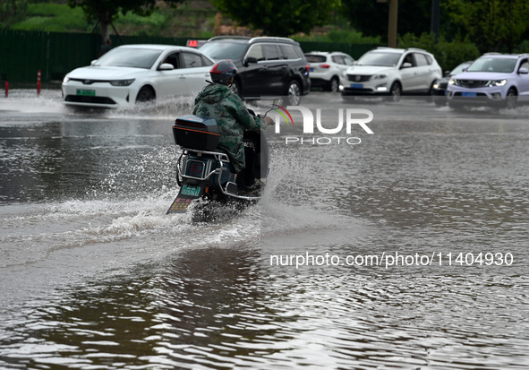 Citizens are traveling on a flooded road in Neijiang, Sichuan province, China, on July 13, 2024. 