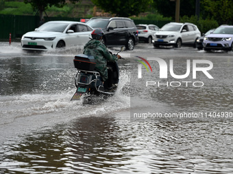 Citizens are traveling on a flooded road in Neijiang, Sichuan province, China, on July 13, 2024. (