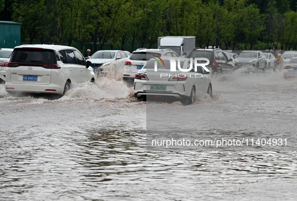 Citizens are traveling on a flooded road in Neijiang, Sichuan province, China, on July 13, 2024. 