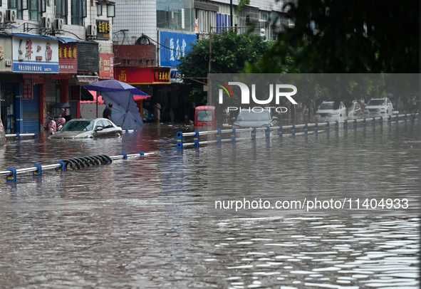 Vehicles are being trapped by a flooded road in Neijiang, China, on July 13, 2024. 