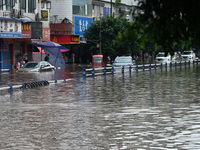 Vehicles are being trapped by a flooded road in Neijiang, China, on July 13, 2024. (