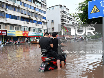 Citizens are traveling on a flooded road in Neijiang, Sichuan province, China, on July 13, 2024. (