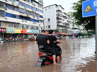 Citizens are traveling on a flooded road in Neijiang, Sichuan province, China, on July 13, 2024. (