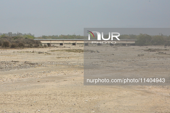 A bridge is spanning a river that is completely drying up in Najibabad, Uttar Pradesh, India, on April 19, 2024. 