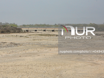 A bridge is spanning a river that is completely drying up in Najibabad, Uttar Pradesh, India, on April 19, 2024. (