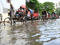 People and vehicles are trying to move through the waterlogged street in Dhaka, Bangladesh, on July 26, 2024 (