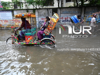 People and vehicles are trying to move through the waterlogged street in Dhaka, Bangladesh, on July 26, 2024 (