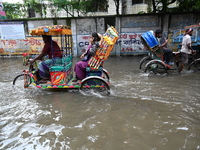 People and vehicles are trying to move through the waterlogged street in Dhaka, Bangladesh, on July 26, 2024 (