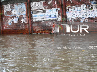 People and vehicles are trying to move through the waterlogged street in Dhaka, Bangladesh, on July 26, 2024 (