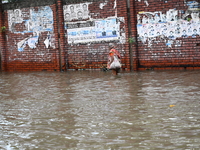 People and vehicles are trying to move through the waterlogged street in Dhaka, Bangladesh, on July 26, 2024 (