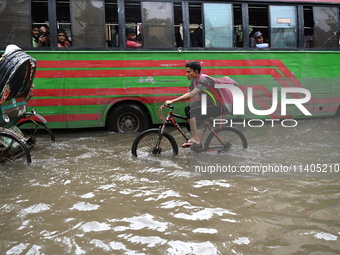 People and vehicles are trying to move through the waterlogged street in Dhaka, Bangladesh, on July 26, 2024 (