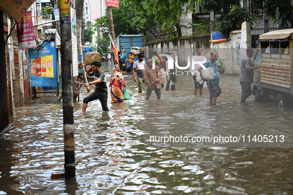 People and vehicles are trying to move through the waterlogged street in Dhaka, Bangladesh, on July 26, 2024 