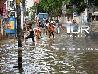 People and vehicles are trying to move through the waterlogged street in Dhaka, Bangladesh, on July 26, 2024 (