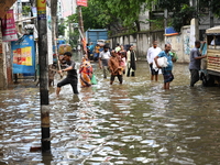 People and vehicles are trying to move through the waterlogged street in Dhaka, Bangladesh, on July 26, 2024 (