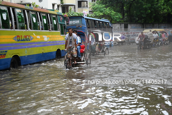 People and vehicles are trying to move through the waterlogged street in Dhaka, Bangladesh, on July 26, 2024 