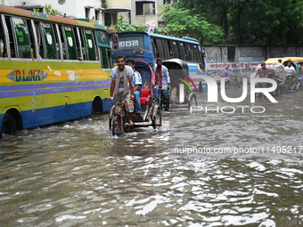 People and vehicles are trying to move through the waterlogged street in Dhaka, Bangladesh, on July 26, 2024 (