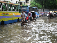 People and vehicles are trying to move through the waterlogged street in Dhaka, Bangladesh, on July 26, 2024 (