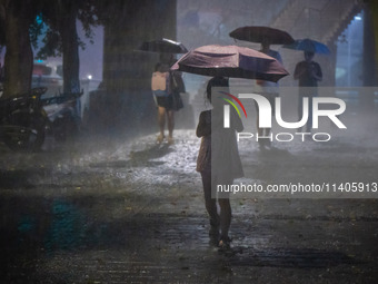 Citizens are walking through the rainstorm in central Chongqing, China, on July 13, 2024. (