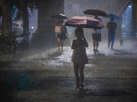 Citizens are walking through the rainstorm in central Chongqing, China, on July 13, 2024. (