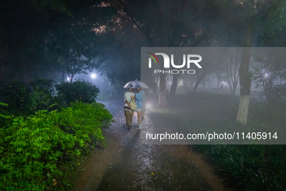 Citizens are walking through the rainstorm in central Chongqing, China, on July 13, 2024. 