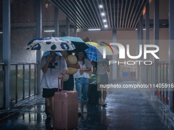 Citizens are walking through the rainstorm in central Chongqing, China, on July 13, 2024. (