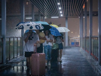 Citizens are walking through the rainstorm in central Chongqing, China, on July 13, 2024. (