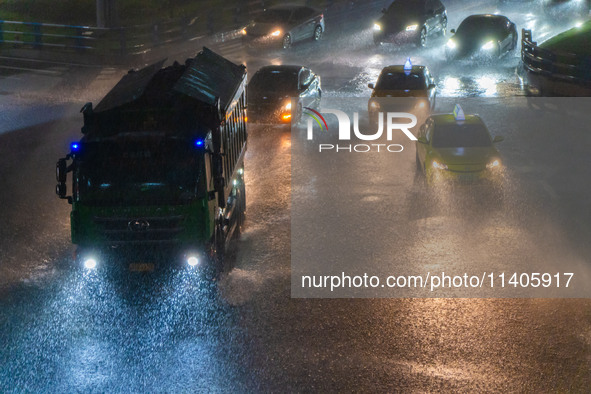 Citizens are walking through the rainstorm in central Chongqing, China, on July 13, 2024. 