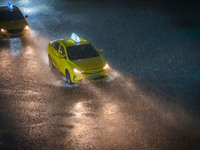 Vehicles are driving in the rainstorm in central Chongqing, China, on July 13, 2024. (