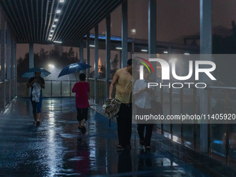 Citizens are walking through the rainstorm in central Chongqing, China, on July 13, 2024. (