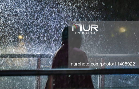 Citizens are walking through the rainstorm in central Chongqing, China, on July 13, 2024. 