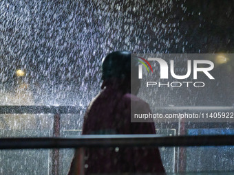 Citizens are walking through the rainstorm in central Chongqing, China, on July 13, 2024. (