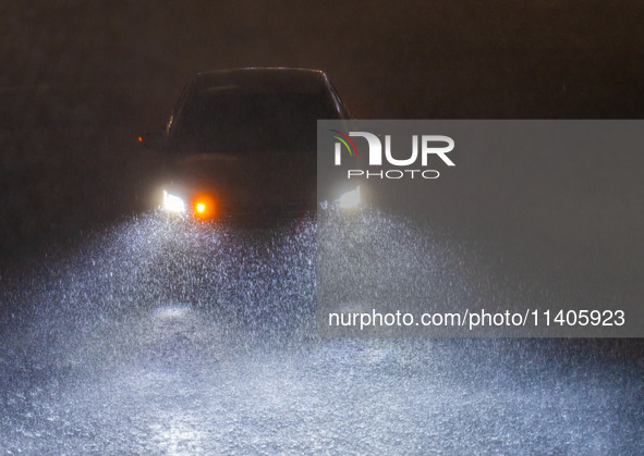 Vehicles are driving in the rainstorm in central Chongqing, China, on July 13, 2024. 