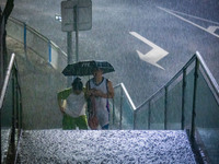 Citizens are walking through the rainstorm in central Chongqing, China, on July 13, 2024. (