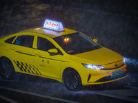 A taxi is driving in the rainstorm in central Chongqing, China, on July 13, 2024. (