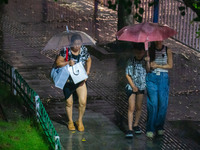 Citizens are walking through the rainstorm in central Chongqing, China, on July 13, 2024. (